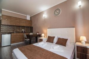1 dormitorio con 1 cama grande y reloj en la pared en Sea Towers Lux 605 en Batumi