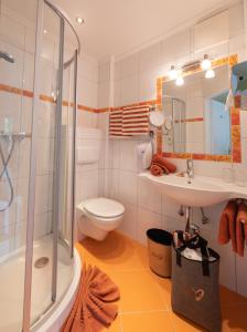 a bathroom with a shower and a sink and a toilet at Boutique Hotel Martha in Zell am See