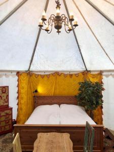 a bed in a tent with a table and a chandelier at Grand Circus Hotel in Malmö