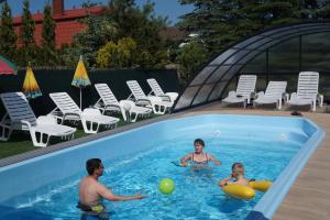 a group of people playing in a swimming pool at Villa Clipper - 5 minut od plaży in Grzybowo