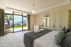 a bedroom with a large bed and a large window at The Mediteran Hotel in Kalkan