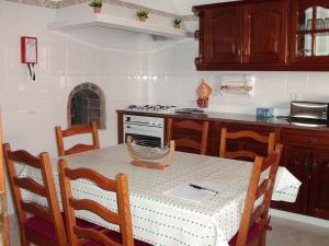 a kitchen with a table with chairs and a stove at Moradia perto dos Palmares in Lagos