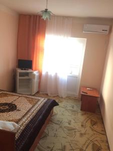 - une chambre avec un lit et une fenêtre dans l'établissement Guest House Emiliya, à Yakornaya Shchel'