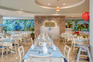 a dining room with tables and chairs and a mural at La Blanche Resort & Spa in Turgutreis