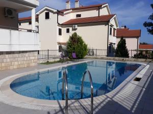 a swimming pool in front of a house at Lila apartmani in Baošići