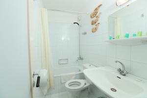 a white bathroom with a toilet and a sink at Cimer SafraMarine Beach Resort in Safra