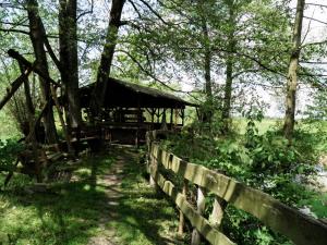 a wooden pavilion in a field next to a fence at Agroturystyka "Pod złotą rybką" in Wolany