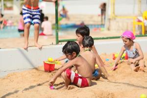 a group of children playing in the sand at a beach at Cimer SafraMarine Beach Resort in Safra