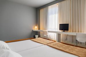a hotel room with a television and a bed at Basic Braga by Axis in Braga