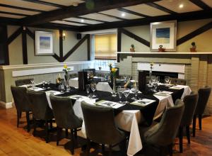 une salle à manger avec une grande table et des chaises dans l'établissement Fox and Goose Inn, à Brent Knoll