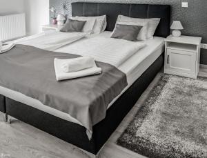 A bed or beds in a room at Aranymandula apartmanok