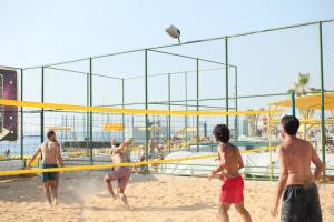 a group of men playing volleyball on a beach at Cimer SafraMarine Beach Resort in Safra