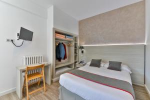 a bedroom with a bed and a desk with a chair at Hostal Soler in Sant Joan de Vilatorrada