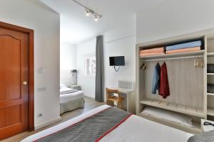 a bedroom with two beds and a closet at Hostal Soler in Sant Joan de Vilatorrada