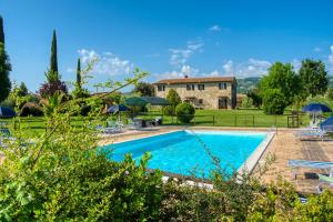 una villa con piscina di fronte a un edificio di Agriturismo Le Terre del Casale ad Assisi
