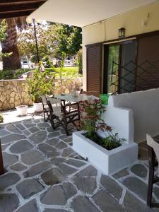 a patio with a table and chairs and an umbrella at Avra Ηouse in Kriopigi