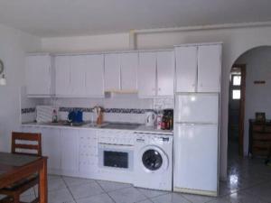 kuchnia z białymi szafkami, kuchenką i lodówką w obiekcie Casa Hibiscus sehr schönes Appartment zum relaxen w mieście Costa Calma