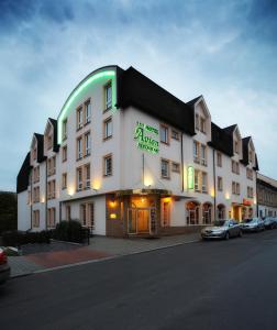 un gran edificio blanco con un letrero verde. en Hotel Avion en Praga