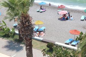 een groep mensen op een strand met parasols bij Hotel Berlin in Fethiye