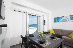 a dining room with a table and a couch at Svevo Sea House in Vieste