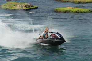 a woman riding a jet ski in the water at Cimer SafraMarine Beach Resort in Safra