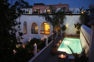 a villa with a swimming pool at night at Riad Clémentine in Marrakech