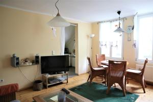 a living room with a table and chairs and a television at Altes Gärtnerhaus in Lübben