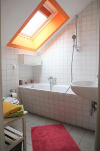 La salle de bains est pourvue d'une baignoire, d'un lavabo et d'une lucarne. dans l'établissement Altes Gärtnerhaus, à Lübben