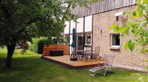 a wooden deck with a table and chairs in a yard at Gästewohnung A+C Bovet in Strasen