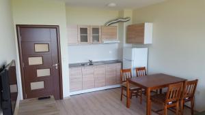 eine Küche mit einem Tisch und Stühlen sowie einem Kühlschrank in der Unterkunft Astarta Riviera Nature in Goldstrand