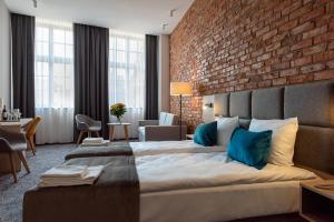 a hotel room with a large bed and a brick wall at Korona Hotel Wroclaw Market Square in Wrocław