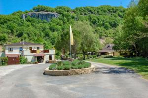 a road with a house and a flag in the middle at Parc de vacances La Draille in Souillac