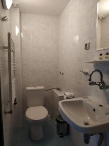 a bathroom with a white toilet and a sink at Dedovite Kashti in Stefanovo