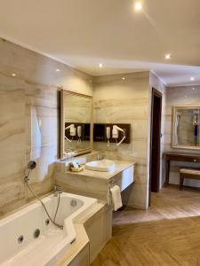 baño grande con bañera y lavamanos en Alaaddin Beach Hotel - Adult Only, en Alanya