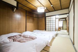 a room with four white beds in it at Kyomachiya Real Kyoto Wabisabi in Kyoto