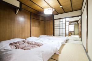 Zimmer mit 4 weißen Betten in der Unterkunft Kyomachiya Real Kyoto Wabisabi in Kyoto