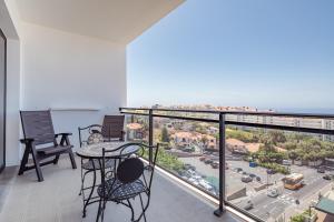 balcón con sillas y mesa y vistas a la ciudad en Elegant Apartment with Sea Views by Trip2Portugal, en Funchal