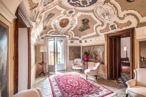 een sierlijke kamer met een plafond met schilderijen bij Baroni Giampiccolo Suite in Ragusa