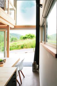 eine Küche mit einem großen Fenster sowie einem Tisch und Stühlen in der Unterkunft Premium Design Ferienhäuser Mosel Chalets in Pommern