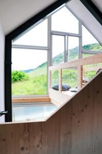 une chambre avec une grande fenêtre dans une maison dans l'établissement Premium Design Ferienhäuser Mosel Chalets, à Pommern