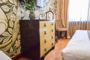 ein Schlafzimmer mit einer Kommode neben einem Bett in der Unterkunft Shato Luxe in Odessa