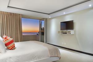 a bedroom with a bed and a large window at Ravensteyn in Cape Town