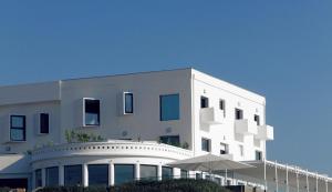 ein weißes Gebäude mit einem Schirm davor in der Unterkunft Le Grand Hotel de la Plage in Biscarrosse-Plage