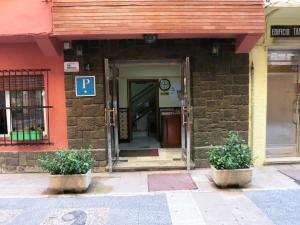 wejście do budynku z dwoma doniczkami z przodu w obiekcie Hostal Guillot w mieście Torremolinos