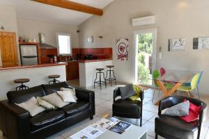 a living room with a couch and chairs and a kitchen at Le Mas des Genets in Saint-Rémy-de-Provence