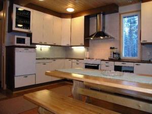 eine Küche mit weißen Schränken und einer hölzernen Arbeitsplatte in der Unterkunft Holiday Home Kurrela by Interhome in Toiviaiskylä