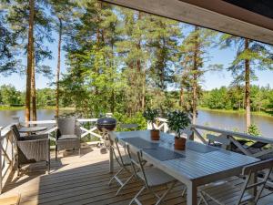 eine Terrasse mit einem Tisch, Stühlen und einem Grill in der Unterkunft Holiday Home Kivitasku by Interhome in Hirsjärvi