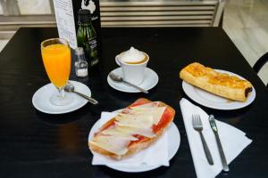 
a table with two plates of food and a glass of orange juice at Hotel Costa Andaluza in Motril
