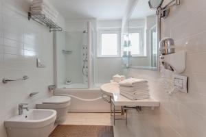 a white bathroom with a sink and a toilet at Kontiki in Milano Marittima +12 photos