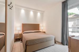 a small bedroom with a bed and a window at Kontiki in Milano Marittima